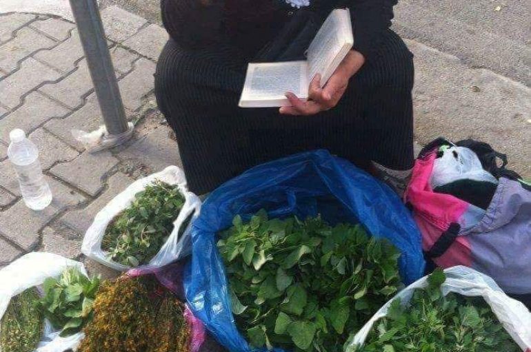 E ulur në trotuar, mban në duart e rrudhosura një libër