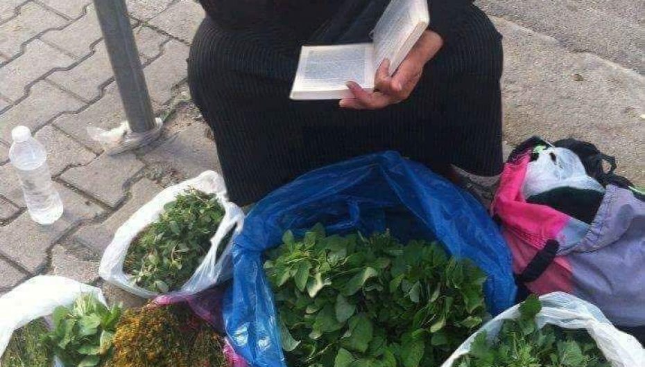 E ulur në trotuar, mban në duart e rrudhosura një libër