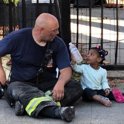 z0uyq-little-girl-offers-firefighter-water