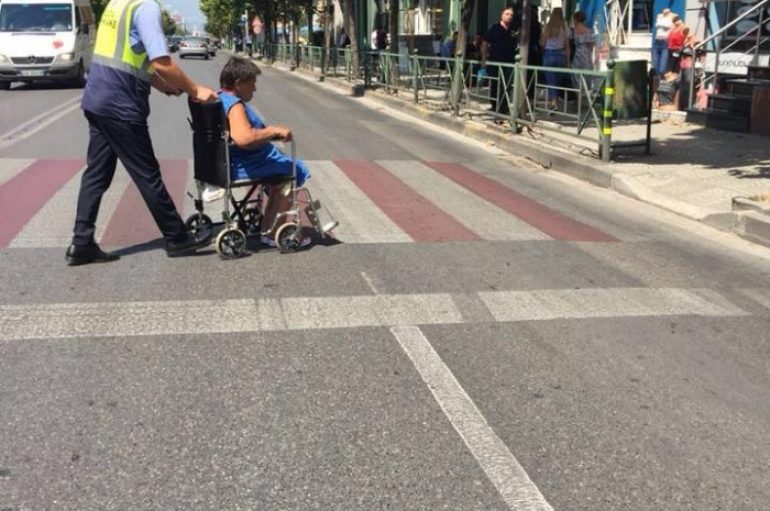 Gjesti human i efektivit, ndihmon një zonjë të kalojë rrugën